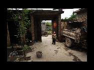 Yue Xiaoming plays in the family's courtyard in Yangquan village. [China.org.cn]