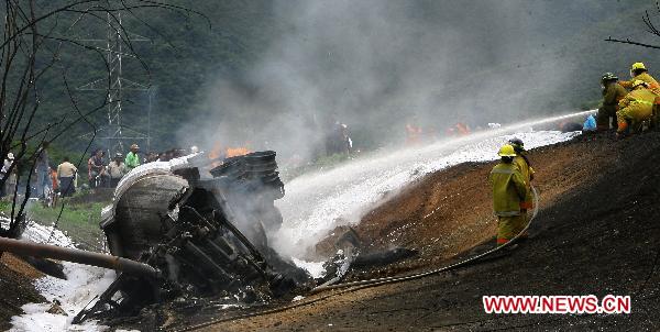 Firefighters try to put out the fire of a blasted oil tank on the highway in Guacara, Carabobo state of Venezuela, Aug. 26, 2010. [Xinhua] 