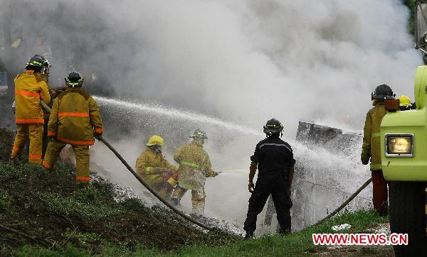 Firefighters try to put out the fire of a blasted oil tank on the highway in Guacara, Carabobo state of Venezuela, Aug. 26, 2010. [Xinhua] 