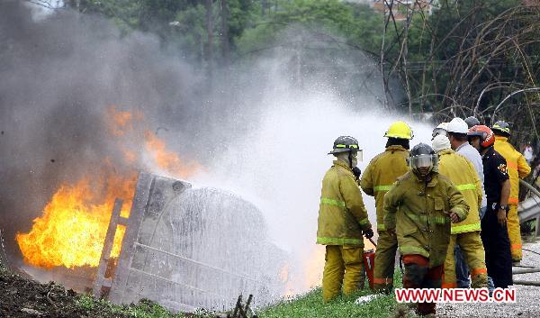 Firefighters try to put out the fire of a blasted oil tank on the highway in Guacara, Carabobo state of Venezuela, Aug. 26, 2010. [Xinhua] 