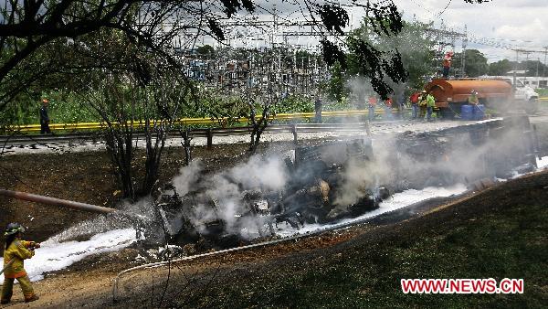 Firefighters try to put out the fire of a blasted oil tank on the highway in Guacara, Carabobo state of Venezuela, Aug. 26, 2010. [Xinhua] 