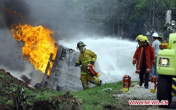 Firefighters try to put out the fire of a blasted oil tank on the highway in Guacara, Carabobo state of Venezuela, Aug. 26, 2010. [Xinhua] 