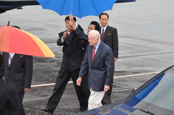 Former U.S. President Jimmy Carter (front) arrives at an airport in Pyongyang, the Democratic People's Republic of Korea, Aug. 27, 2010. Former U.S. President Jimmy Carter left Pyongyang Friday, taking home the U.S. man Aijalon Mahli Gomes detained in the Democratic People's Republic of Korea (DPRK) since January for illegal entry. [Yao Ximeng/Xinhua]