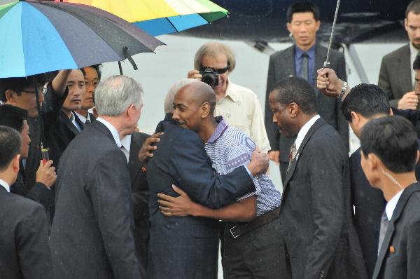 Former U.S. President Jimmy Carter (left C) hugs with the U.S. man Aijalon Mahli Gomes (right C) at an airport in Pyongyang, the Democratic People's Republic of Korea, Aug. 27, 2010. Former U.S. President Jimmy Carter left Pyongyang Friday, taking home the U.S. man Aijalon Mahli Gomes detained in the Democratic People's Republic of Korea (DPRK) since January for illegal entry.[Yao Ximeng/Xinhua]