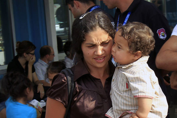 A Roma family arrives back home together with about 300 other Roma on planes departing from Paris and Lyon, in the latest wave of what French President Nicholas Sarkozy's government calls a voluntary repatriation scheme, Bucharest, August 26, 2010. [Xinhua]