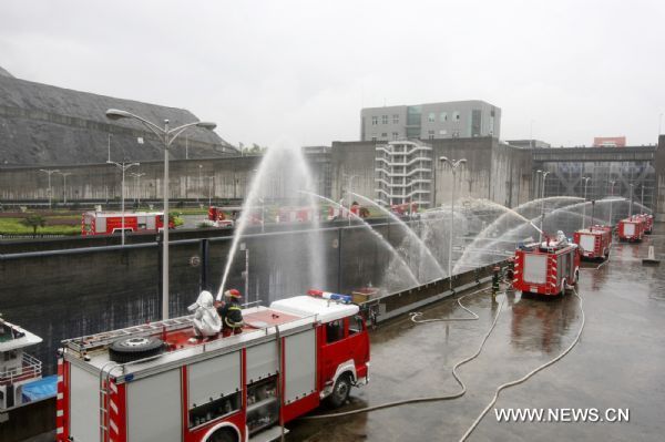 Fire engines spay water to vessels locked in the Three Gorges Dam during a fire drill in Yichang, central China's Hubei Province, Aug. 26, 2010. Some 200 staff members from local public service departments joined in the drill Thursday. [Xinhua photo]