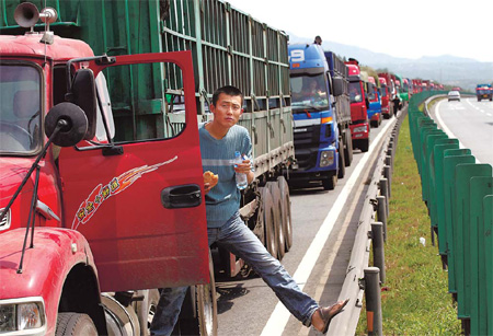 A driver takes his lunch while waiting in the long traffic jam on the Beijing-Tibet expressway on Friday. [China Daily]