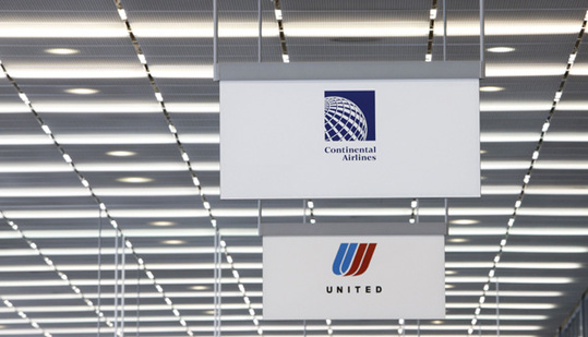 A Continental Airlines sign is seen next to a United Airlines sign in Chicago's O'Hare International Airport May 3, 2010. The U.S. Justice Department on Friday approved a merger between United Airlines and its rival Continental Airlines, a deal that would create the world's largest carrier. [Xinhua/Reuters File Photo]