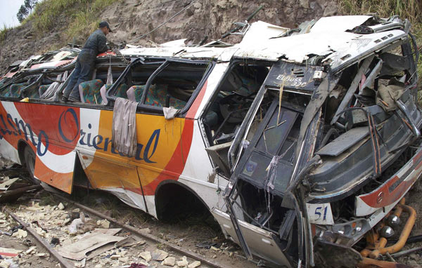 An Ecuadorian worker ties a cord on the debris of a bus in Latacunga, 70 km (43.5 miles) south of Quito August 29, 2010. A bus winding its way through Ecuador&apos;s highlands toward the capital of Quito went off the road before dawn on Sunday, killing 38 passengers in the worst accident of this kind in the country in years. [China Daily/Agencies]
