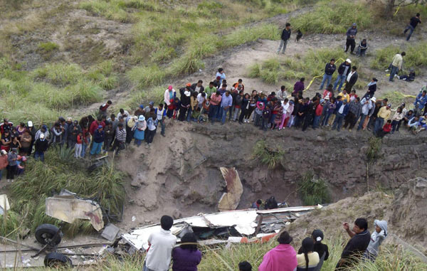 Dwellers look at the debris of a bus in Latacunga, 70 km (43.5 miles) south of Quito August 29, 2010. [China Daily/Agencies]