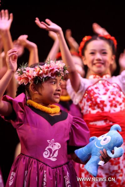 Hawaiian girls and Chinese girls of Shanghai Soong Ching Ling Foundation Children's Palace Art Troupe wave to the audience after performance in Honolulu, Hawaii, the United States, Aug. 27, 2010. Forty-five students of the art troupe arrived in the resort on Aug. 24 to spend five days with their counterpart in Hawaii and to promote the Shanghai 2010 World Expo. 