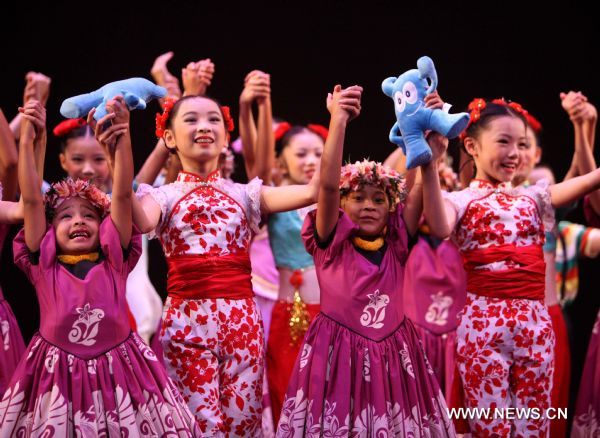 Hawaiian girls and Chinese girls of Shanghai Soong Ching Ling Foundation Children's Palace Art Troupe gesture to the audience after performance in Honolulu, Hawaii, the United States, Aug. 27, 2010. Forty-five students of the art troupe arrived in the resort on Aug. 24 to spend five days with their counterpart in Hawaii and to promote the Shanghai 2010 World Expo. 