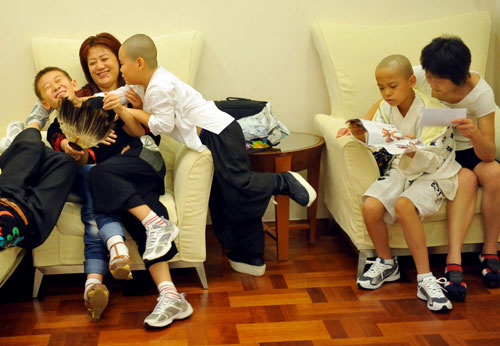 Young Peking opera performers have fun with their mothers in the waiting hall of the National Center for the Performing Arts before the rehearsal of Red Cliff, Beijing, Aug 27, 2010. [Xinhua]