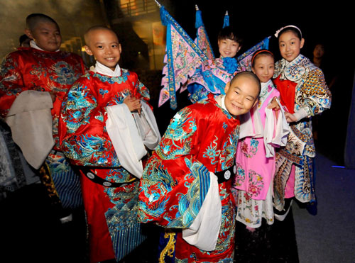 Children in costume pose for pictures backstage at the National Center for the Performing Arts, Beijing, Aug 26, 2010. [Xinhua] 