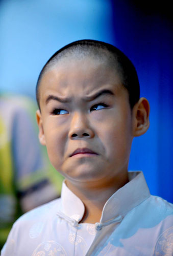 A young performer shows a typical facial expression of Peking Opera during the rehearsal for Red Cliff at the National Center for the Performing Arts, Beijing, Aug 23, 2010. [Xinhua]