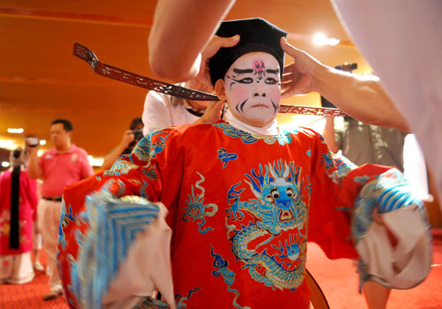 A young performer gets dressed before he goes on the stage at the National Center for the Performing Arts, Beijing, Aug 23, 2010. [Xinhua] 