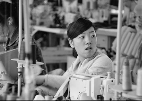 A woman operates a machine at a textile factory in Jiangsu province. Some companies have reportedly moved their factories to Southeast Asian countries due to rising labor costs after 27 provincial regions in China raised minimum wages. [China Daily]