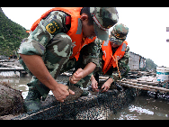 Soldiers help fasten a fishing boat in Fuzhou, Fujian province, Aug 31, 2010. [Xinhua]