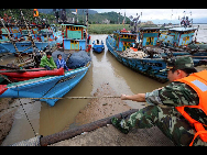 Soldiers help fasten a fishing boat in Fuzhou, Fujian province, Aug 31, 2010. [China Daily]