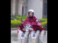 A motorist is seen in rain in Fuqing City of southeast China's Fujian Province, Aug. 31, 2010.  (Xinhua/Wei Peiquan) 