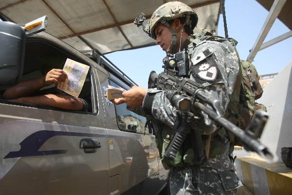 An Iraqi soldier hands out a leaflet calling on citizens to be attentive to militant activity at a checkpoint in central Baghdad on August 31, 2010. Prime Minister Nuri al-Maliki told Iraqis their own soldiers and police are up to the job as US forces ended a combat role after seven years of fighting that has cost thousands of lives.[Xinhua/AFP]