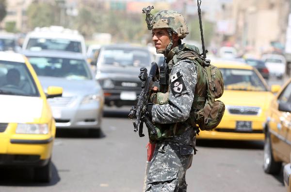 An Iraqi soldier stands at a checkpoint in Baghdad on August 31, 2010.[Xinhua/AFP]