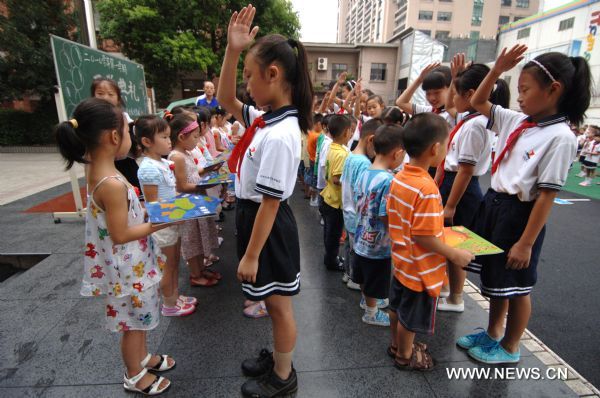 Students of higher grades give presents to those of lower grades at a school in Hangzhou, capital of east China&apos;s Zhejiang Province, Sept. 1, 2010. Most primary schools and middle schools in China started the new semester Wednesday. [Xinhua] 