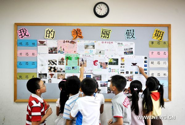 Students look at their homeworks at a school in Beijing, capital of China, Sept. 1, 2010. Most primary schools and middle schools in China started the new semester Wednesday. [Xinhua] 