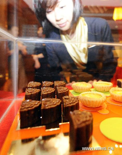 A citizen is attracted by a coffee mooncake at Changchun Shangri-la Hotel, northeast China's Jilin Province, on Aug. 31, 2010. Mooncake manufacturers have waged wars on the market more than 20 days before the traditional Mid-Autumn Day. A mooncake tasting meeting was held at Changchun Shangri-la Hotel on Tuesday, attacting visitors from home and abroad to taste various curious mooncakes. [Wang Haofei/Xinhua]