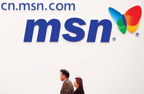 Two visitors pass an advertisement for MSN at a recent auto exhibition in Beijing. [China Daily]