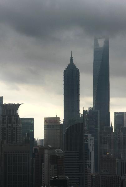 Dark cloud is seen over downtown Shanghai, east China, Aug. 31, 2010. Heavy rains and thunderstorms are predicted to hit Shanghai as this year's six, seventh and eighth tropical storms are active at sea in east China.