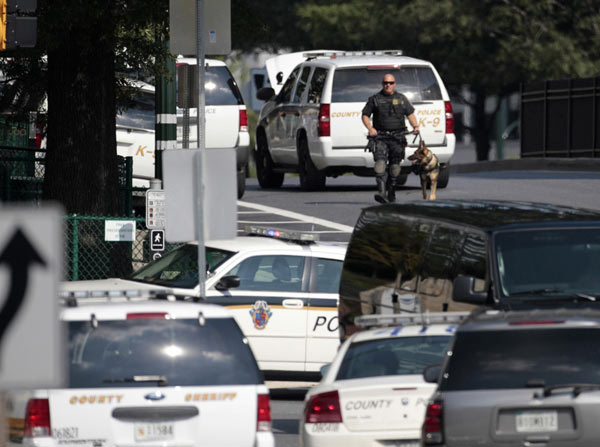 A police K-9 unit officer approaches the Discovery Channel headquarters building in Silver Spring, Maryland, September 1, 2010. [China Daily/Agencies]