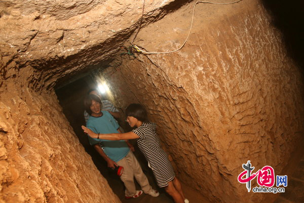 Chen Xinnian and his wife stand in the passage that leads to their safe room in Zhengzhou, capital of Central China&apos;s Henan province. [CFP] 