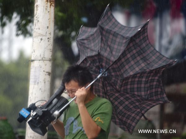 A journalist struggles in strong wind in Zhangzhou City, southeast China's Fujian province, Sept. 2, 2010. 