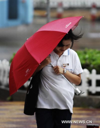 A woman walks against rainstorm in Shishi City, southeast China's Fujian Province, Sept. 2, 2010.