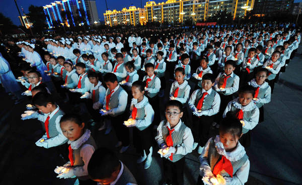Chinese students hold candles during a ceremony to commemorate the 65th anniversary of the end of World War II in Heihe, Northeast China&apos;s Heilongjiang province, Sept 2, 2010. [Xinhua] 