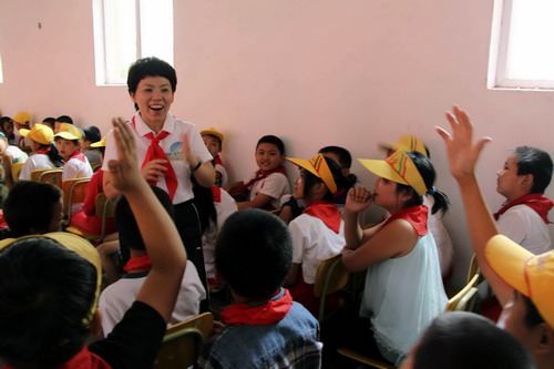 Deng Yaping laughs during class interactions with floating children at Huilei Primary School in Beijing on Sept 2, 2010.[Xinhua]