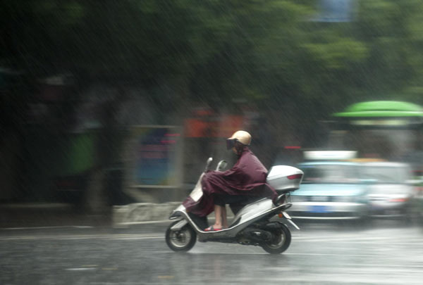 A motor bike rider braves the rain in Zhangzhou city, Southeast China&apos;s Fujian province, Sept 2, 2010. [Xinhua]