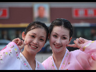 The DPRK performers from Pyongyang Art Troupe, dressed in traditional costumes, pose for a photo on the Tiananmen Square in Beijing during their touring trip to China, September 1, 2010. [Xinhua]