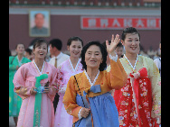 The DPRK performers from Pyongyang Art Troupe, dressed in traditional costumes, pose for a photo on the Tiananmen Square in Beijing during their touring trip to China, September 1, 2010. [Xinhua]