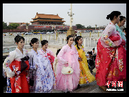 The DPRK performers from Pyongyang Art Troupe, dressed in traditional costumes on the Tiananmen Square in Beijing during their touring trip to China, September 1, 2010. [Chinanews.com]