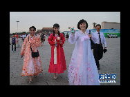 The DPRK performers from Pyongyang Art Troupe, dressed in traditional costumes, pose for a photo on the Tiananmen Square in Beijing during their touring trip to China, September 1, 2010. [Xinhua]