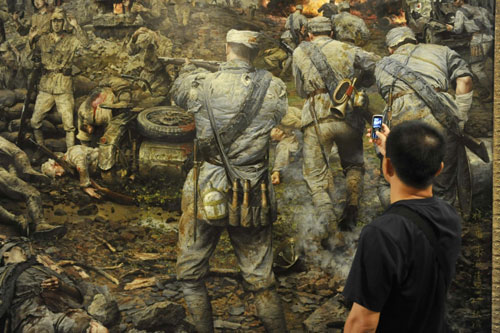 A visitor appreciates a painting at an exhibition in Beijing Sept 2, 2010, commemorating the 65th anniversary of the victory of the Chinese People&apos;s anti-Japanese War. [Xinhua] 