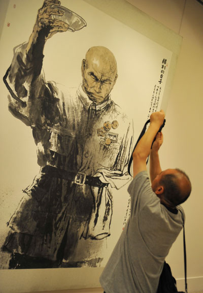 A visitor takes photos of a painting at an exhibition in Beijing Sept 2, 2010, commemorating the 65th anniversary of the victory of the Chinese People’s anti-Japanese War. [Xinhua]