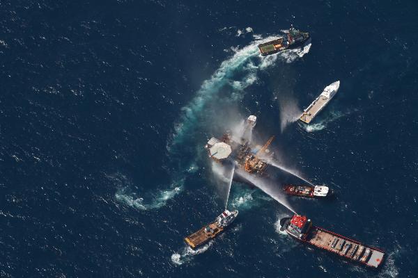 Boats are seen spraying water on an oil and gas platformthat exploded in the Gulf of Mexico, off the coast ofLouisiana,September 2, 2010. [Xinhua]