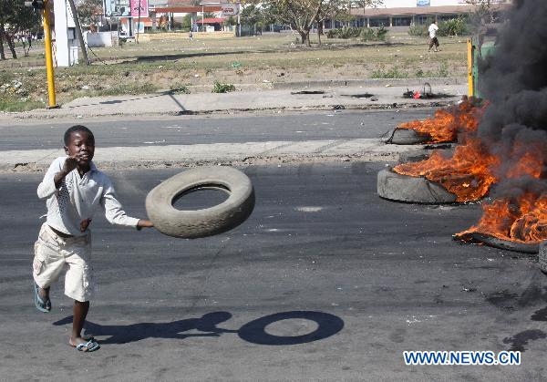 A boy throws a tyre in the riot in Maputo, capital of Mozambique, Sept. 1, 2010. [Xinhua]