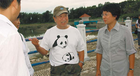 Pan Wenshi, center, a renowned professor and wildlife expert with Peking University, chats with Xiao Yingzi, right, mayor of Qinzhou, about how to prevent the Chinese white dolphins and their habitat in Sanniang Bay from being affected by the invasive economic development.