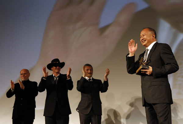 Director John Woo waves after receiving a Golden Lion for Lifetime Achievement as directors Marco Muller (L), Quentin Tarantino and Tsui Hark applaud during the closing ceremony of the 66th Venice Film Festival September 3, 2010. [Xinhua]