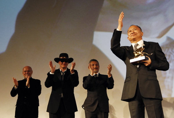 Director John Woo (R) waves after receiving a Golden Lion for Lifetime Achievement as Directors Marco Muller (L), Quentin Tarantino and Tsui Hark applaud during the closing ceremony of the 66th Venice Film Festival September 3, 2010. [Xinhua]