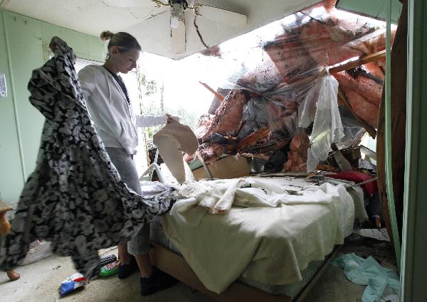 Velma Saunders helps clean out a relative's trailer home that was destroyed by a fallen tree during Hurricane Earl in Manteo, North Carolina September 3, 2010. [Xinhua/Reuters]